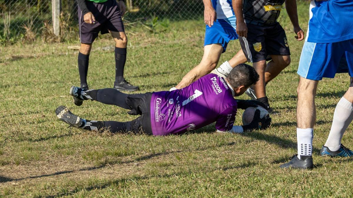 Soccer player on ground in purple jersey during game.